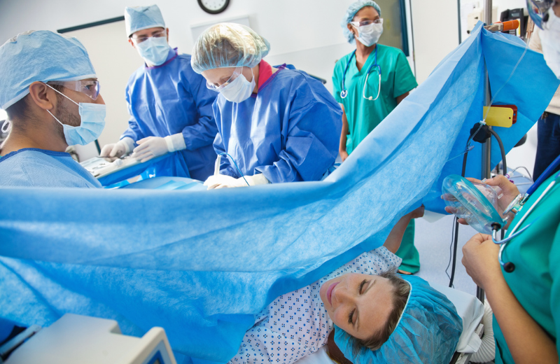 Surgical team performing Caesarean section on pregnant woman